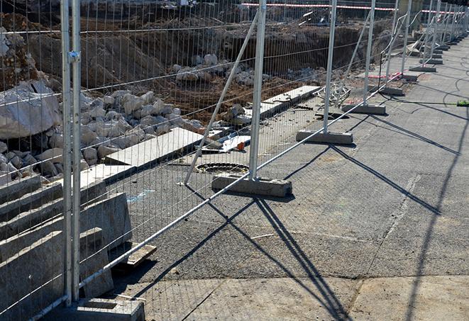 a temporary fence panel installation that helps to prevent debris from getting out of the construction site